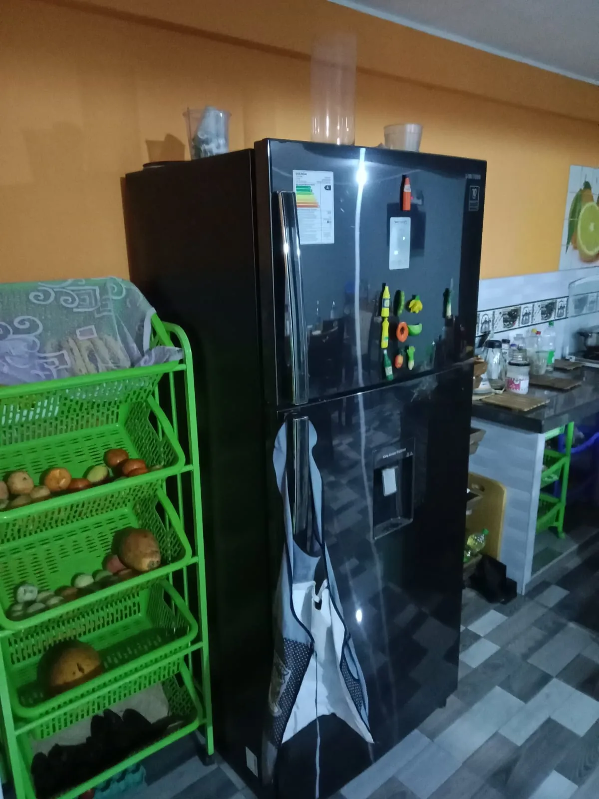 Black top-freezer refrigerator standing in a home kitchen