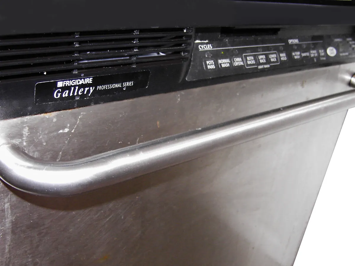 Close view of a stainless dishwasher door and its control strip