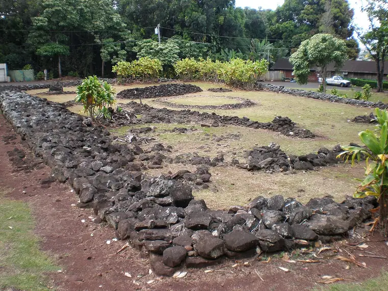 Low stone walls of Keaiwa Heiau in the hillside recreation area above the town