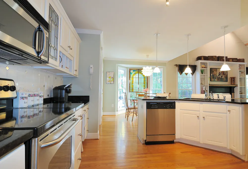 Open kitchen with a stainless range, a wall microwave and a built-in dishwasher