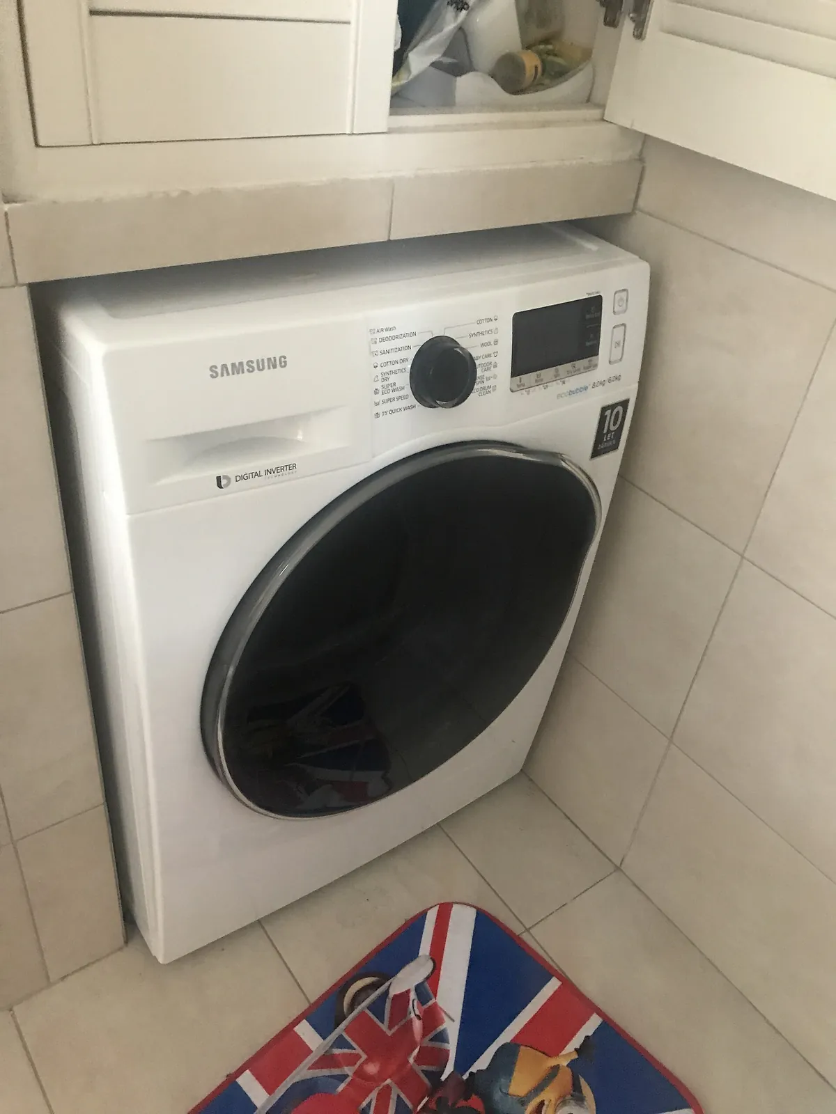 Samsung front-load washer in a tiled laundry corner