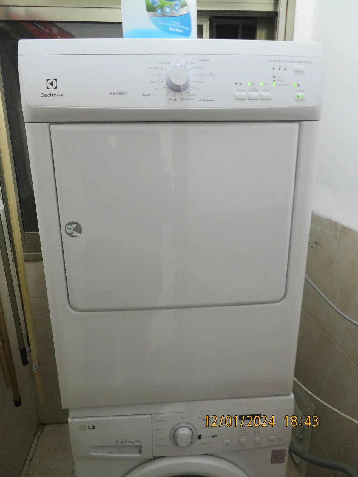 Front-load clothes dryer stacked on top of a washer