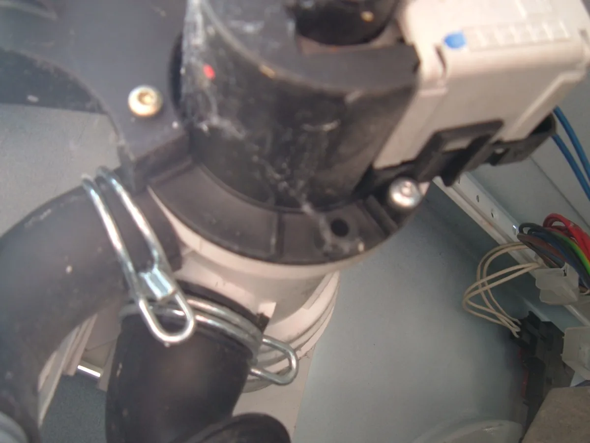 Close view of a washing machine drain pump with its hose and clamp